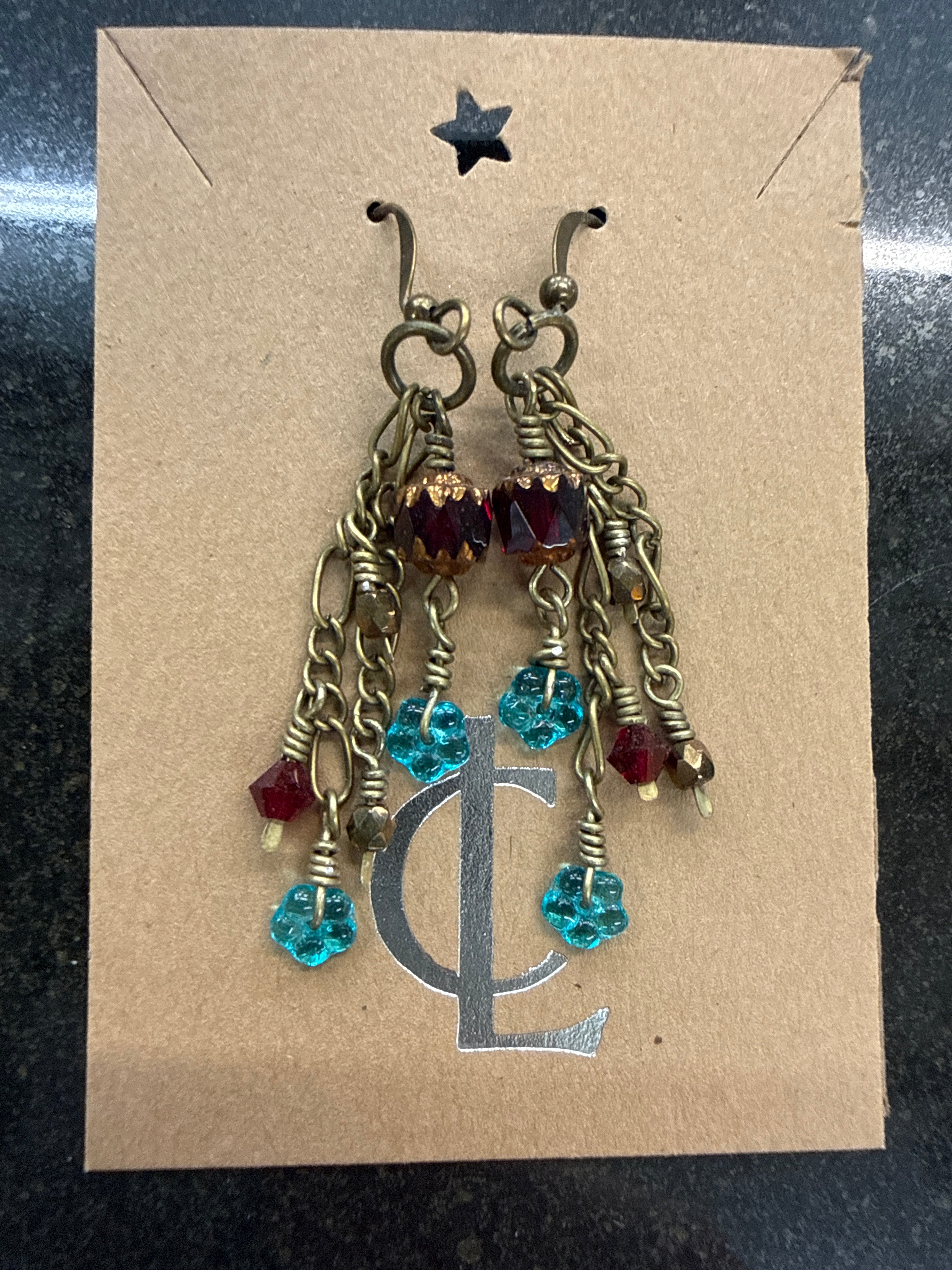 Earrings: Red Czech glass beads, tel flower beads with hand forged brass chain. E25